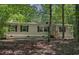 Charming single-story home featuring neutral siding, black shutters, and a wooded lot at 130 S Creek Dr, Louisburg, NC 27549