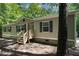 Exterior view of the home, showing the front door, gray siding, black shutters, and front yard at 130 S Creek Dr, Louisburg, NC 27549