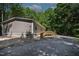 View of the home showing the side, ramp, and deck nestled in a green, wooded area at 130 S Creek Dr, Louisburg, NC 27549
