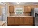 Kitchen with wood cabinets, stainless appliances, and a double basin sink with large window at 130 S Creek Dr, Louisburg, NC 27549
