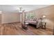 Inviting living room with wood-look floors, a comfortable sofa, and natural light from the window at 130 S Creek Dr, Louisburg, NC 27549