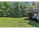 Expansive backyard featuring a spacious wooden deck, lush lawn, and privacy from the surrounding mature trees at 1325 Red Brick Rd, Garner, NC 27529