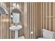 Charming half bathroom with wallpaper, classic fixtures, and traditional design elements at 1325 Red Brick Rd, Garner, NC 27529