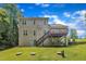 Back exterior of house with second story deck, lush lawn, and steps to the back door at 1325 Red Brick Rd, Garner, NC 27529