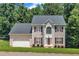 Charming two-story home with a two-car garage, a manicured lawn, and elegant architectural details at 1325 Red Brick Rd, Garner, NC 27529