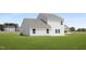 A spacious backyard with green grass surrounds the home's exterior at 142 Benson Village Dr # 82, Benson, NC 27504