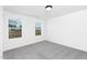 An empty bedroom with carpet, two windows and bright light at 142 Benson Village Dr # 82, Benson, NC 27504