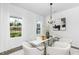Bright dining room features modern chandelier, glass table, neutral chairs and white walls at 142 Benson Village Dr # 82, Benson, NC 27504