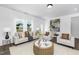 Bright living room with large windows, neutral furniture, white walls and wood floors at 142 Benson Village Dr # 82, Benson, NC 27504