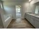 Bathroom features a soaking tub, double vanity, and wood-look flooring at 159 Coharie Dr, Lillington, NC 27546