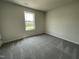 Carpeted bedroom featuring a window overlooking the front yard at 159 Coharie Dr, Lillington, NC 27546