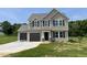 Charming two-story home featuring a two-car garage, a manicured lawn and classic siding at 159 Coharie Dr, Lillington, NC 27546