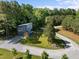 Aerial view of a modern home nestled among lush trees, showcasing its private setting and landscaping at 160 Daphine Dr, Hillsborough, NC 27278