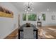 Bright dining room with hardwood floors, a modern light fixture, and large windows offering a serene view at 160 Daphine Dr, Hillsborough, NC 27278