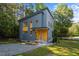 Modern home with blue siding, natural wood accents, professional landscaping, and gravel driveway at 160 Daphine Dr, Hillsborough, NC 27278
