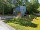 Modern gray home with black trim, surrounded by lush greenery, offering a blend of privacy and style at 160 Daphine Dr, Hillsborough, NC 27278