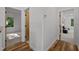 Bright hallway with hardwood floors, white walls, and views into nearby rooms at 160 Daphine Dr, Hillsborough, NC 27278