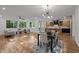 Open-concept living room and kitchen featuring hardwood floors, modern lighting, and large windows at 160 Daphine Dr, Hillsborough, NC 27278