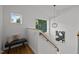 Upstairs landing with modern light fixture, bench, wood railing, and ample natural light at 160 Daphine Dr, Hillsborough, NC 27278