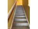 Carpeted stairway with wooden handrail and freshly painted yellow walls at 1671 Holly Grove Way, Durham, NC 27713