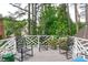 Relaxing back deck offers outdoor seating, a patterned white railing, and views of the surrounding trees at 1813 Carrington Dr, Raleigh, NC 27615