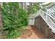 The backyard features green foliage, pine straw ground cover, and access to the deck from the stairs at 1813 Carrington Dr, Raleigh, NC 27615