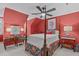 A vibrant bedroom with a four poster bed, bright red walls, and stylish eclectic decor at 1813 Carrington Dr, Raleigh, NC 27615