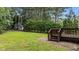 Landscaped backyard with a deck, lush greenery, and a storage shed at 185 Keller Dr, Clayton, NC 27520