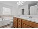 Bathroom featuring double vanity, tub, tile accents and lots of natural light at 185 Keller Dr, Clayton, NC 27520