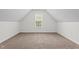Attic bedroom with neutral carpeting and a large window with lots of natural light at 185 Keller Dr, Clayton, NC 27520