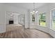Dining room with hardwood floors, large windows, and views into living room with fireplace at 185 Keller Dr, Clayton, NC 27520