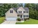 Inviting two-story home with a manicured lawn, black shutters, and a two-car attached garage at 185 Keller Dr, Clayton, NC 27520
