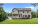 Back exterior view of the home with a well-maintained lawn and wooden deck at 185 Keller Dr, Clayton, NC 27520