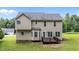 Rear exterior view of the home showcasing the wooden deck and mature landscaping at 185 Keller Dr, Clayton, NC 27520