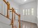 Open foyer with hardwood flooring, decorative front door, and wooden staircase at 185 Keller Dr, Clayton, NC 27520