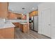 Well-lit kitchen featuring stainless steel appliances, wood cabinets, island, and modern pendant lighting at 185 Keller Dr, Clayton, NC 27520