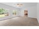 Spacious living room featuring neutral carpet, ceiling fan, and access to back deck at 185 Keller Dr, Clayton, NC 27520