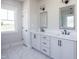 Bright bathroom with a double sink vanity featuring a marble countertop and white cabinets at 188 Banner Elk Rd, Benson, NC 27504