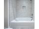 Bathroom featuring a white tiled bathtub and a matching shower with built in shelving at 188 Banner Elk Rd, Benson, NC 27504