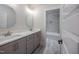 Stylish bathroom featuring double sinks, a light gray vanity, modern fixtures, and a tiled shower and bathtub at 188 Banner Elk Rd, Benson, NC 27504