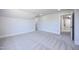 Inviting bedroom features neutral carpet, trim, and paint and an open door to the closet and hallway at 188 Banner Elk Rd, Benson, NC 27504