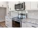 Close up of a kitchen featuring stainless steel appliances, white cabinets, and granite countertops at 188 Banner Elk Rd, Benson, NC 27504