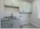 Laundry room with green cabinets, granite counters, and herringbone floors at 188 Banner Elk Rd, Benson, NC 27504