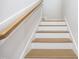 Wooden staircase featuring light wood treads, white risers, and a coordinating handrail at 188 Banner Elk Rd, Benson, NC 27504