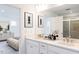 Bathroom featuring double vanity sinks, white cabinets, framed mirrors and a glass shower door at 198 Blue Butterfly Dr, Angier, NC 27501