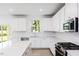Bright kitchen with white cabinets, stainless steel appliances, and white quartz countertops at 198 Blue Butterfly Dr, Angier, NC 27501