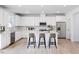 Modern kitchen with large island, white cabinets, stainless steel appliances, and hardwood flooring at 198 Blue Butterfly Dr, Angier, NC 27501