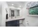Bright bathroom featuring a navy vanity, white countertop, and decorative patterned window valance at 200 W Woodcroft Pkwy # 57B, Durham, NC 27713