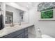 Bright bathroom featuring a navy vanity, white countertop, and decorative patterned window valance at 200 W Woodcroft Pkwy # 57B, Durham, NC 27713