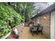 Outdoor deck featuring wood flooring, seating, dining table and surrounded by lush greenery at 200 W Woodcroft Pkwy # 57B, Durham, NC 27713